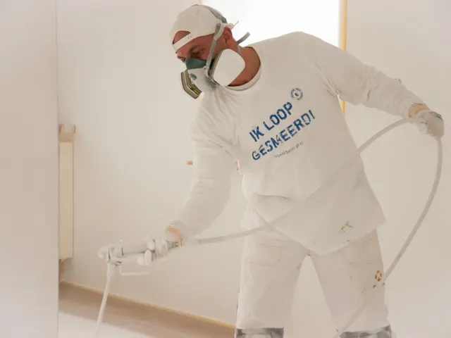De vakman met spuitlans en beschermende kleding