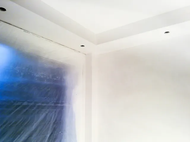 Het plafond wordt afgewerkt bij een afgeplakt raam